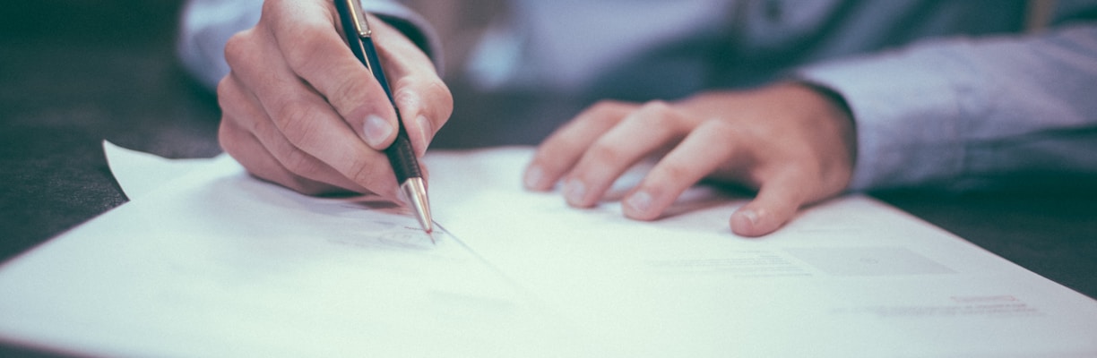 man writing on paper