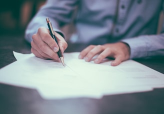 man writing on paper