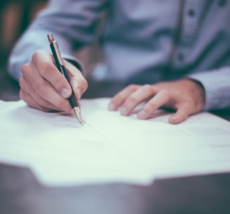 man writing on paper