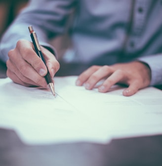 man writing on paper