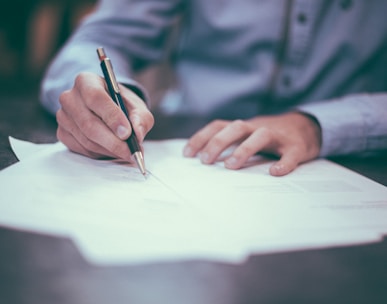 man writing on paper