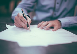 man writing on paper