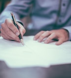 man writing on paper