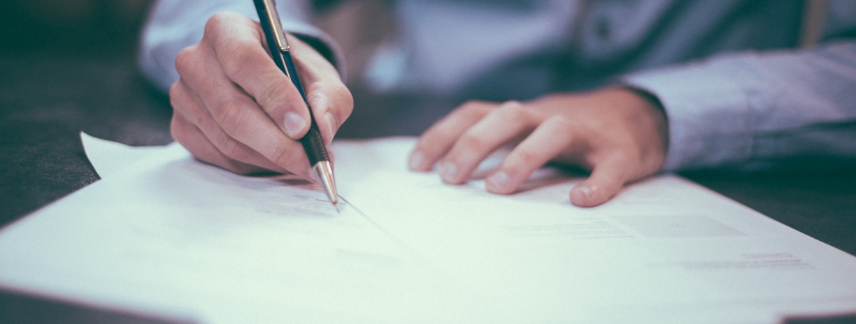 man writing on paper