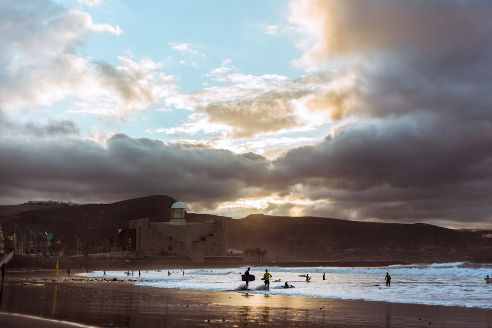 pessoas na praia durante o pôr do sol