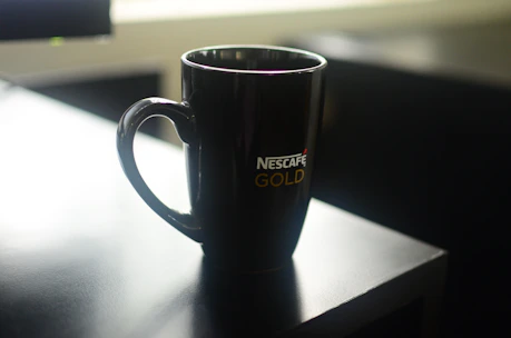 Close-up of a custom printed company logo on a sleek black mug with subtle golden accents.