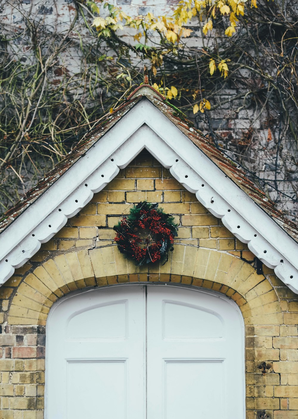 red flower wreath over door