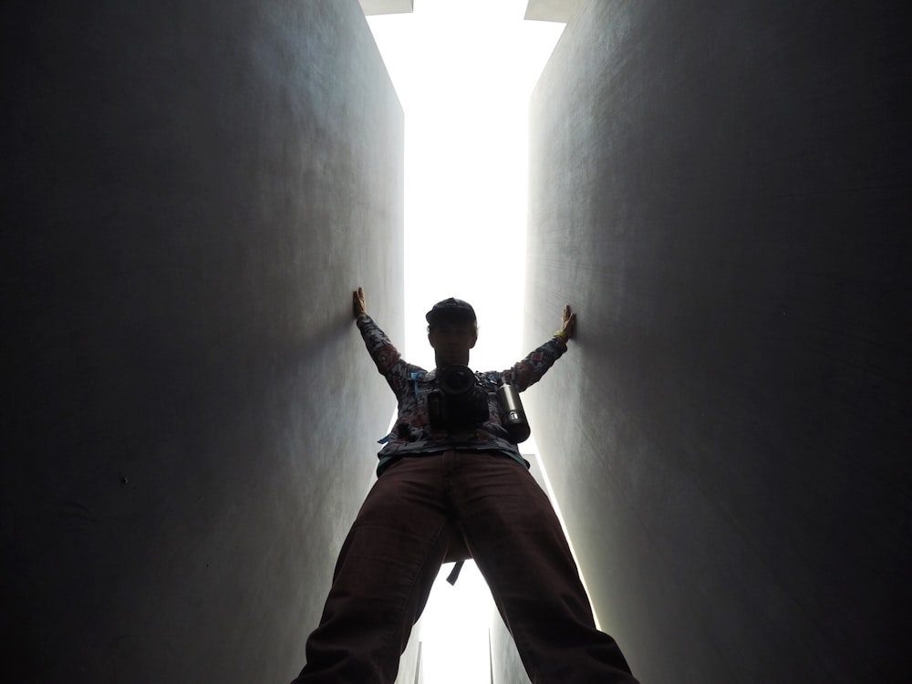 low-angle photo of man standing between walls