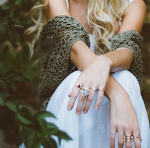 woman sitting beside plant and concrete wall