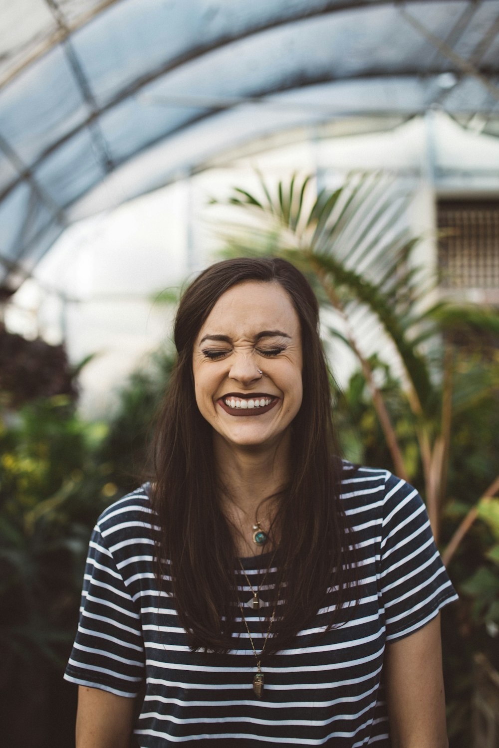 Mujer sonriendo mientras está de pie en el jardín