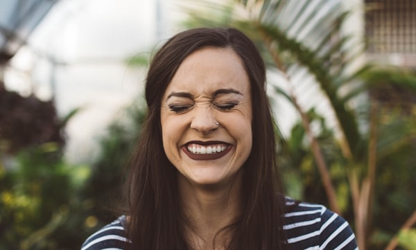 woman smiling while standing in garden