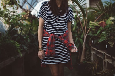 woman wearing black and white striped dress standing in isle near green plants arkansas google meet background