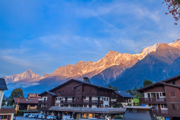A panoramic view of a mountain village at sunset with warm golden light.