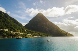 white board on body of water near mountain during daytime