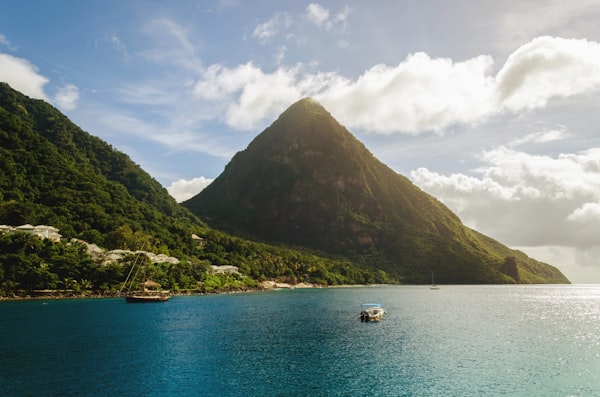 Green tropical hills among Caribbean Seas with a yacht and boat in the bay.