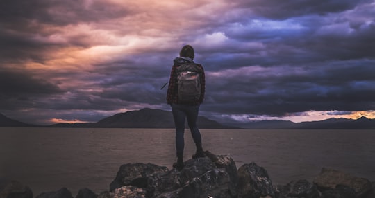 man standing on rock overlooking ocean in Utah Lake State Park United States