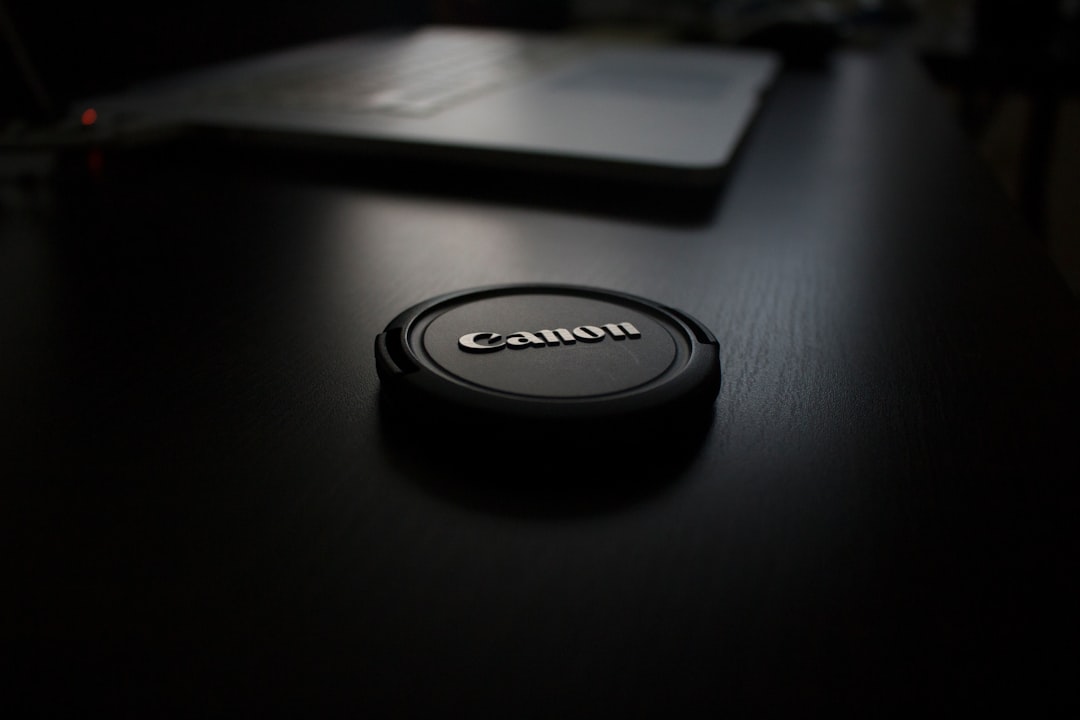 shallow focus photography of black Canon zoom lens cover