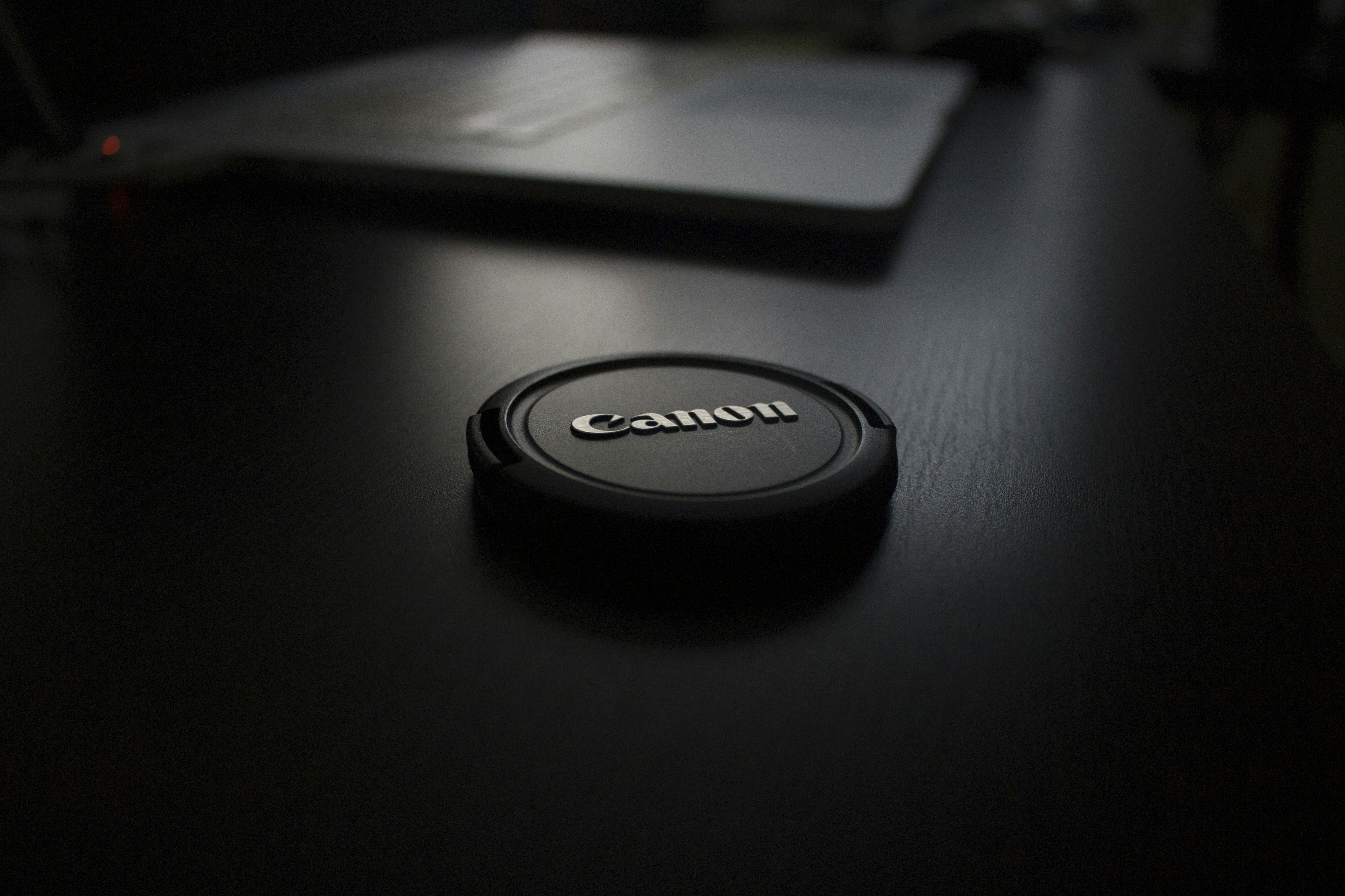 shallow focus photography of black Canon zoom lens cover