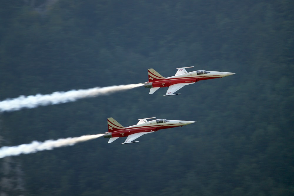 Dois aviões a jato vermelhos e brancos no ar