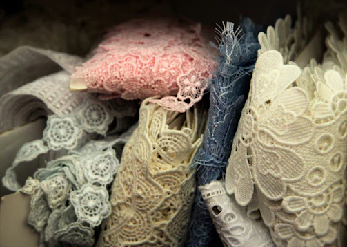 A layered fashion collage featuring delicate lace dresses, pastel accessories, and polished glass surfaces.