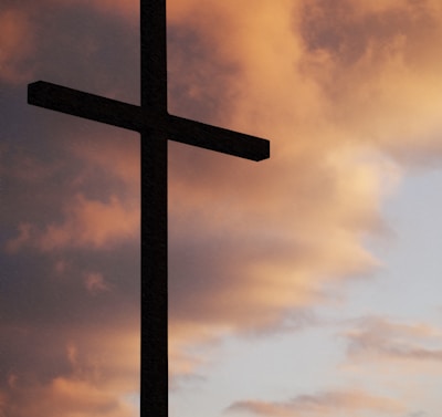 silhouette of large cross under orange sky