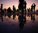 silhouette of people standing on mirror during golden hour