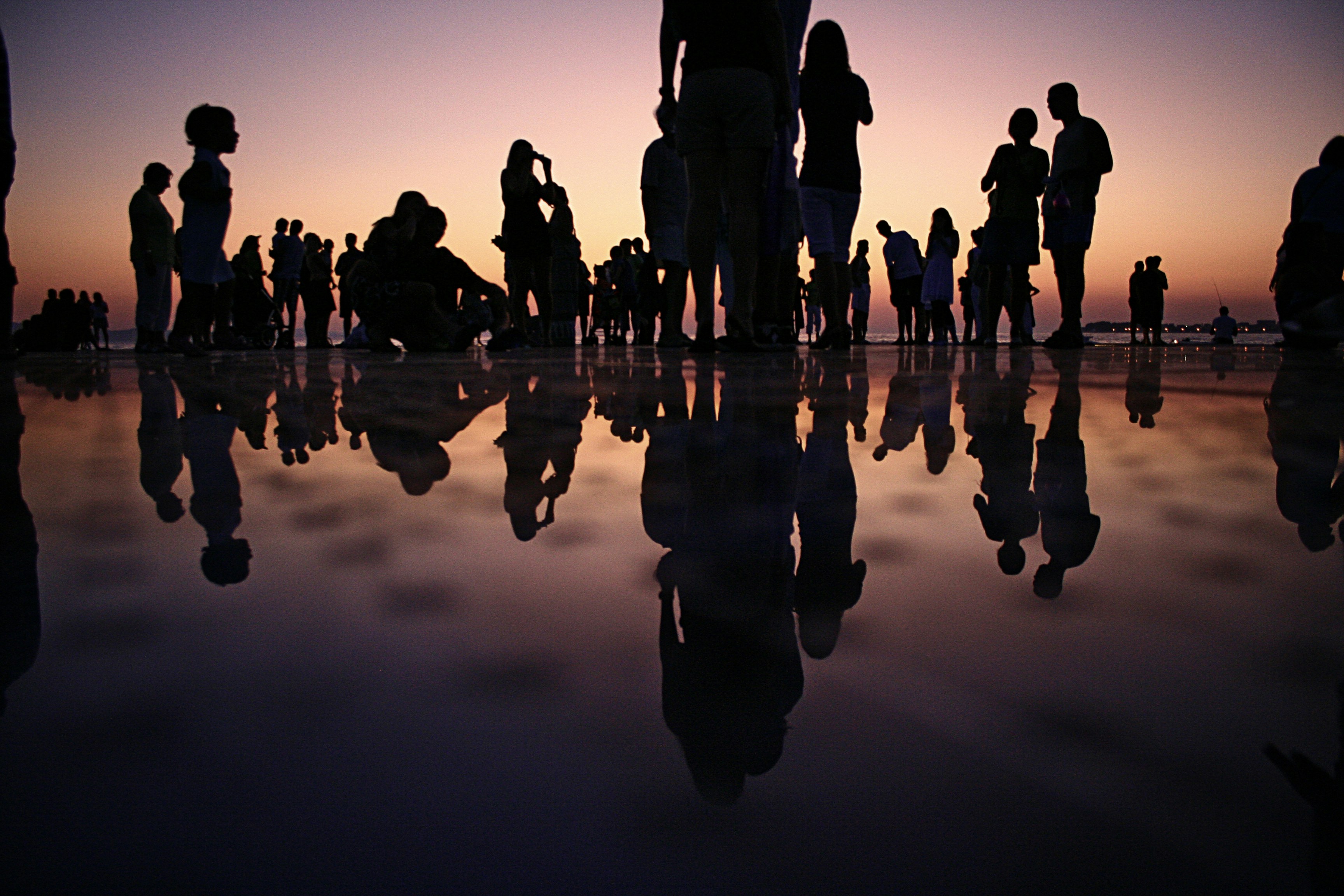 great photo recipe,how to photograph crowd at a party; silhouette of people standing on mirror during golden hour