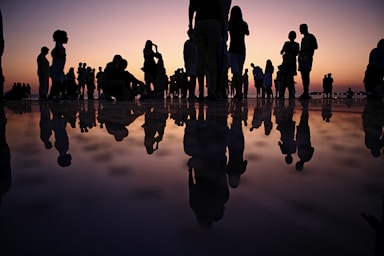 photography poses for big groups,how to photograph crowd at a party; silhouette of people standing on mirror during golden hour