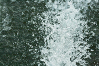 Close-up of a foam water ball releasing bubbles and water droplets in mid-air during a playful splash.