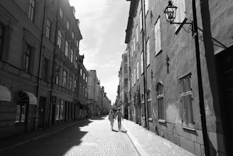 A warm candid photo of Emma and Hannah strolling along a quiet Parisian street lined with classic Haussmann buildings.