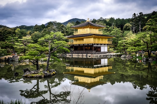 black and brown 3-layer gazebo in middle of water in Kinkaku-ji Japan