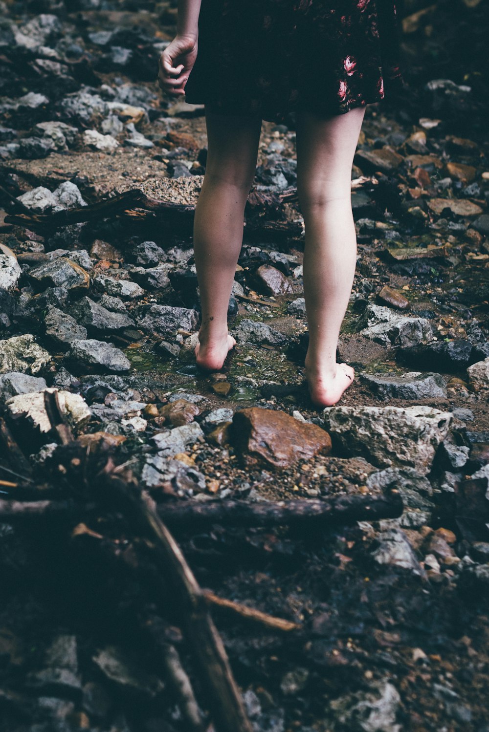 Frau steht auf Felsen mit fließendem Wasser