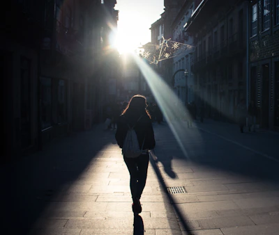 A cheerful traveler with a backpack enjoying a sunny European city street.