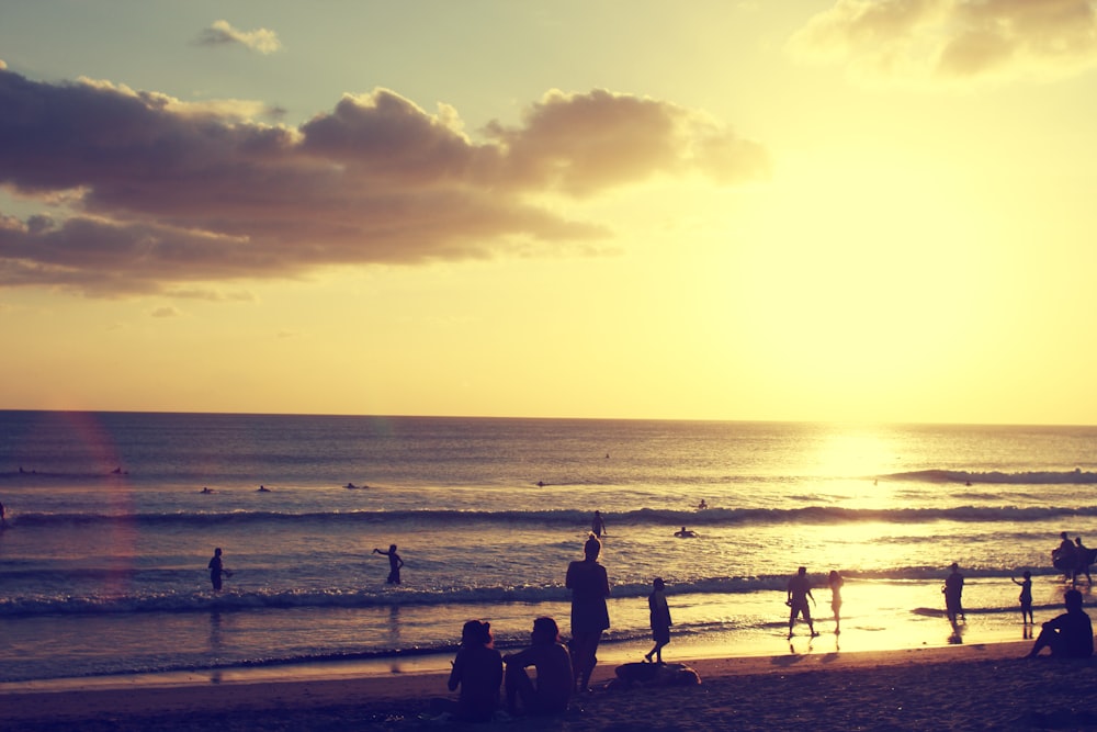 silhouette photography of people standing on shore near sea