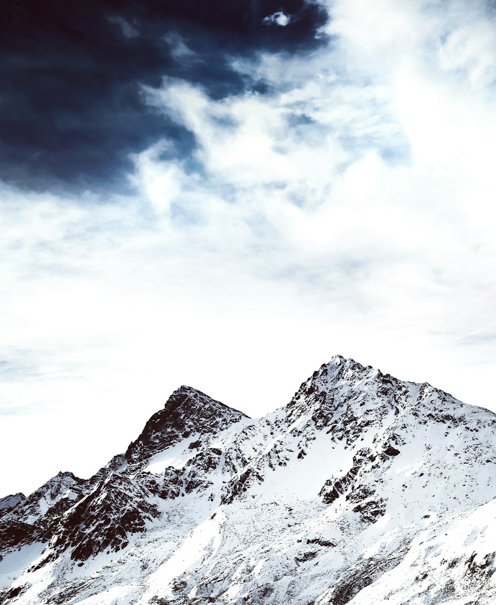 mountain filled of snow under gray cloud