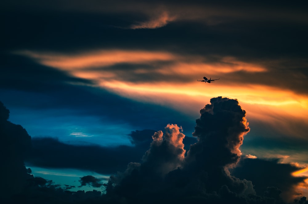 Silueta de avión bajo cielos nublados
