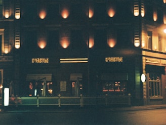 Evening scene of unfoold’s exterior, warm light spilling onto the sidewalk beneath the glowing logo sign.