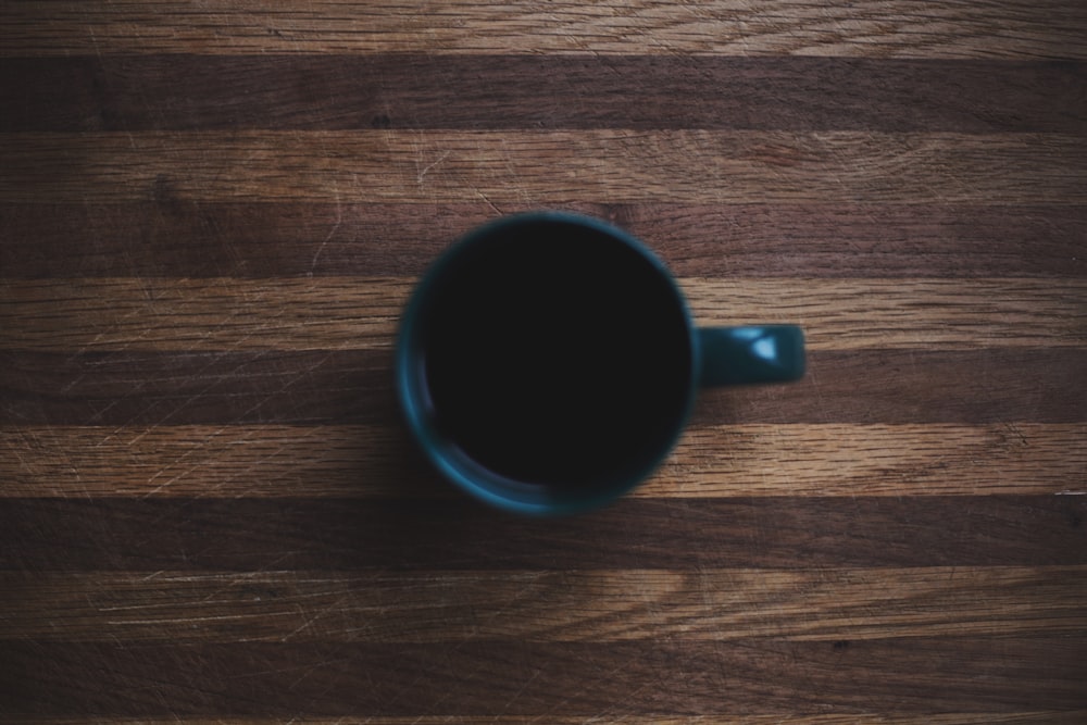 black ceramic mug on wooden surface