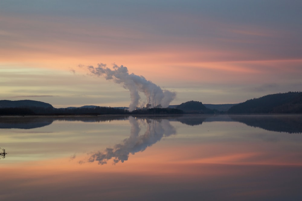 body of water under white clouds during orange sunset