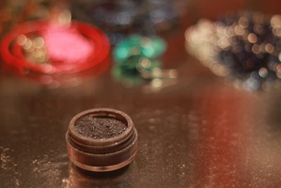 Close-up of a shimmering highlighter compact glowing under soft studio lights.