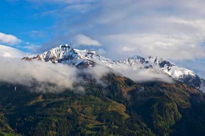 snow capped mountain during white and blue clouds evocative teams background