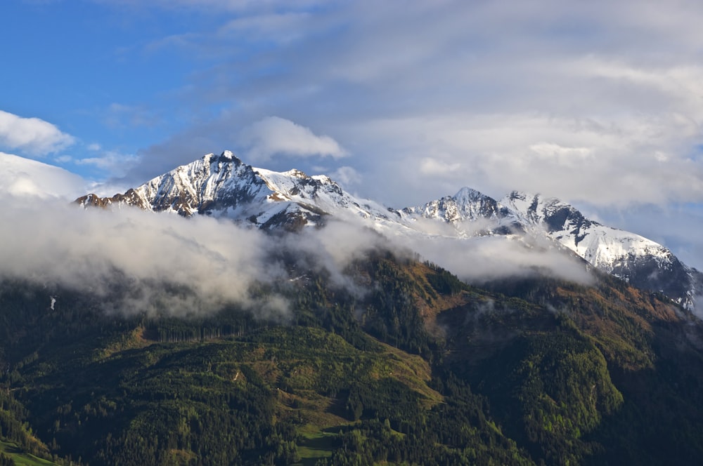 snow capped mountain during white and blue clouds