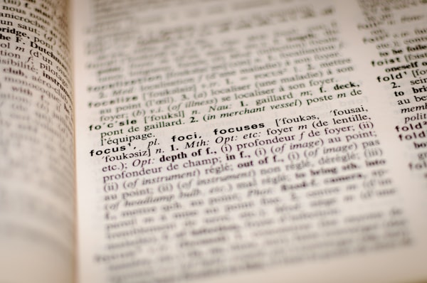 A blurry photo of a dictionary page has the definition of "Focus" in focus.