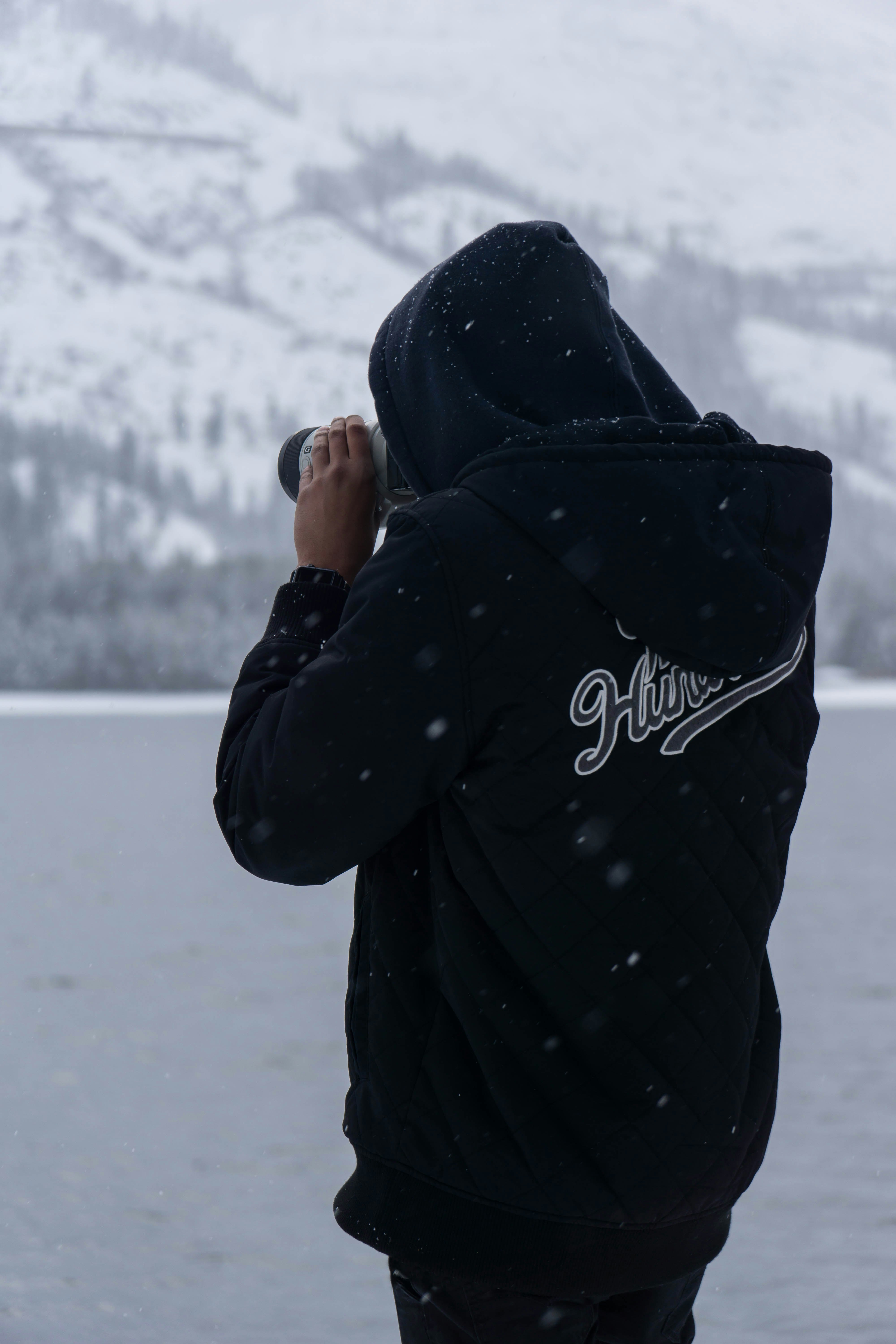 man wears hoodie takes picture during winter