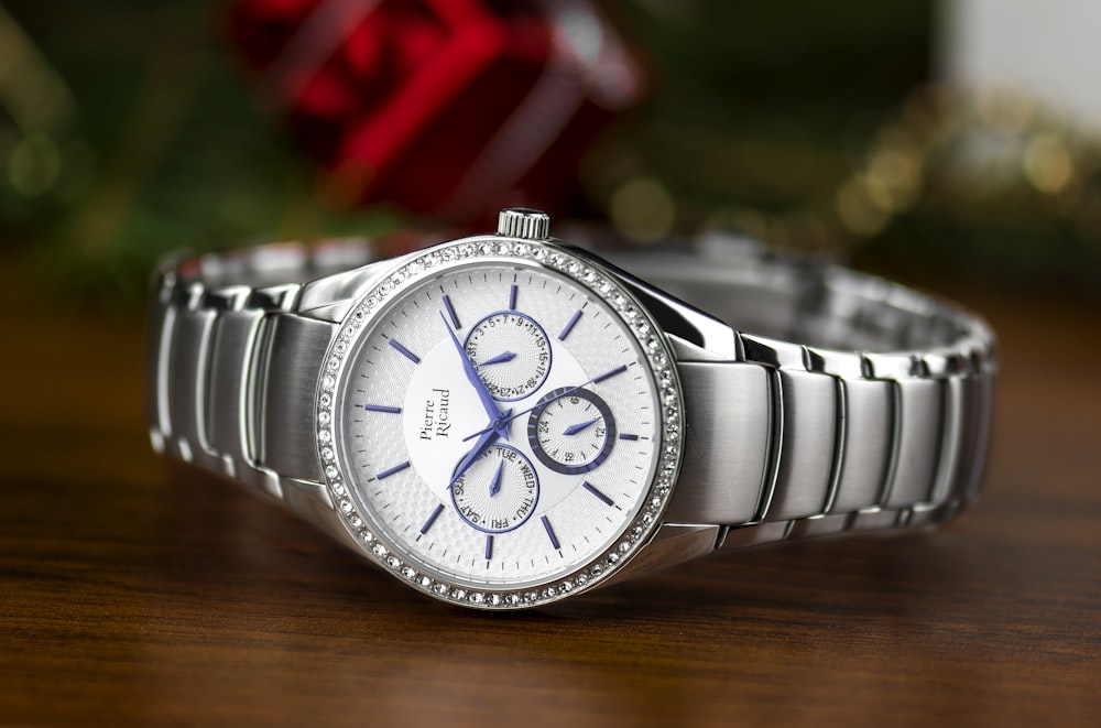 shallow focus photography of silver-colored chronograph watch with link bracelet