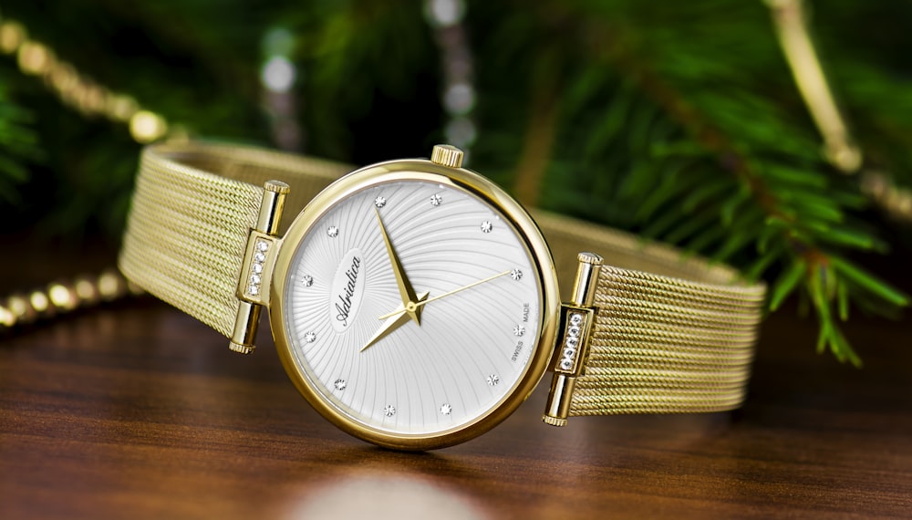 shallow focus photography of round gold-colored analog watch