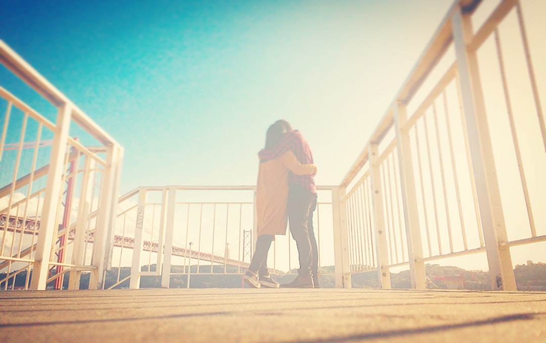 Soft light surrounds lovers on a boardwalk landing
