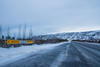 A scenic view of Iceland's landscape with a modern retail storefront in the foreground.