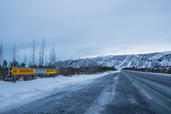 A scenic view of Iceland's landscape with a modern retail storefront in the foreground.