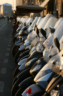 A group of colorful scooters lined up along the scenic beach road of Puri at sunset.